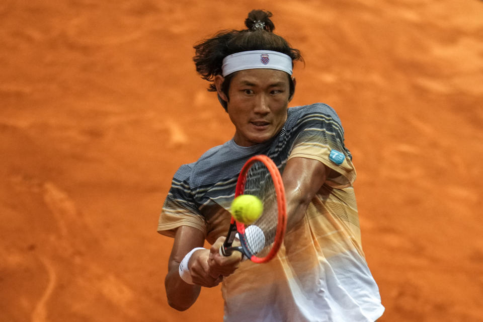 Zhang Zhizhen of China returns the ball against Taylor Fritz, of the United States, during their match at the Madrid Open tennis tournament in Madrid, Spain, Tuesday, May 2, 2023. (AP Photo/Manu Fernandez)