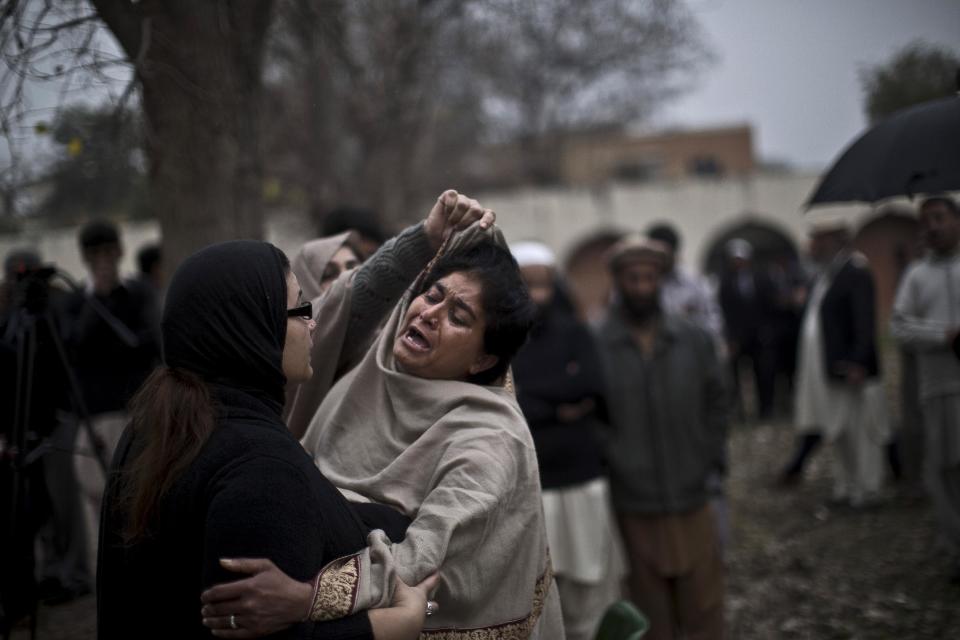 A Pakistani woman comforts a woman grieving outside a hospital's morgue, where the bodies of victims of a twin suicide bombing are, in Islamabad, Pakistan, Monday, March 3, 2014. Two suicide bombers blew themselves up at a court complex in the Pakistani capital on Monday, killing nearly a dozen and wounding scores in a rare terror attack in the heart of Islamabad, officials said. (AP Photo/Muhammed Muheisen)