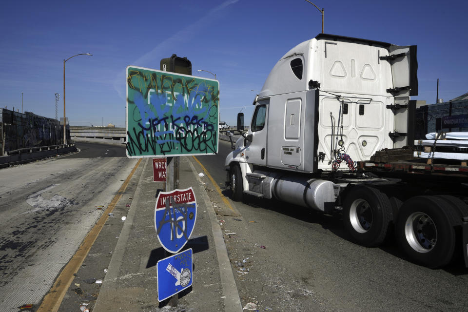 A truck enters a ramp to Interstate 10 in Los Angeles, Tuesday, Nov. 14, 2023. California Gov. Gavin Newsom says a stretch of I-10 in Los Angeles that was burned in an act of arson does not need to be demolished, and that repairs will take an estimated three to five weeks. (AP Photo/Damian Dovarganes)