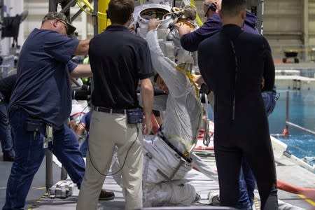 NASA Commercial Crew Astronaut Josh Cassada is helped to wear his space suit at NASA's Neutral Buoyancy Laboratory (NBL) training facility near the Johnson Space Center in Houston,