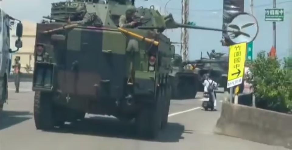 國軍雲豹甲車公路行駛，車載鏈砲砲管將路旁反光鏡及路標撞破、撞倒。 圖：截自解讀國軍軍事新聞臉書粉專影片