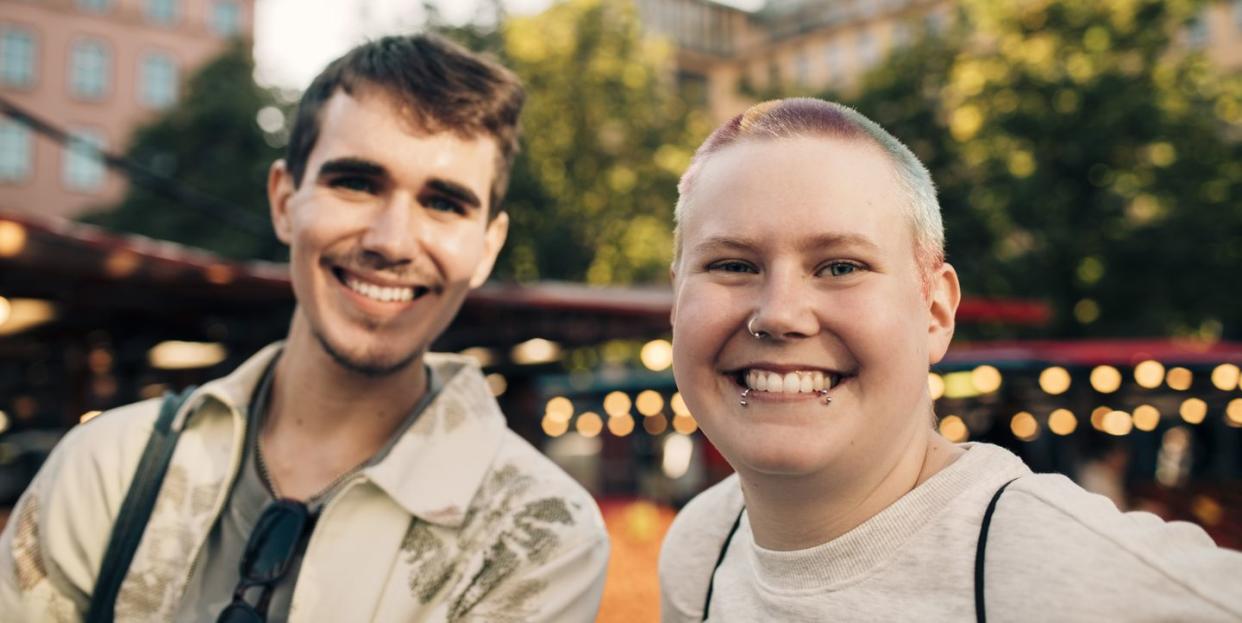 portrait of smiling male friends hanging out in city