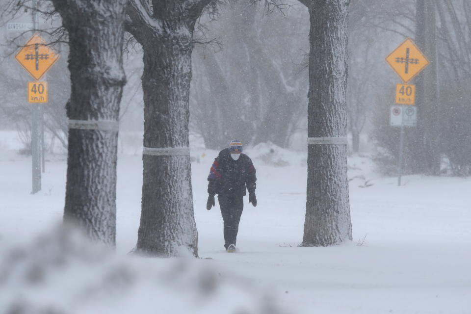 A lone man walks through falling snow as a snowstorm arrives in Winnipeg, Manitoba, Canada April 13, 2022. REUTERS/Shannon VanRaes