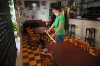 A woman measures the distance between table in a restaurant of Lille, northern France, Tuesday June 2, 2020. The French way of life resumes Tuesday with most virus-related restrictions easing as the country prepares for the summer holiday season amid the pandemic. Restaurants and cafes reopen Tuesday with a notable exception for the Paris region, the country's worst-affected by the virus, where many facilities will have to wait until June 22 to reopen. (AP Photo/Michel Spingler)