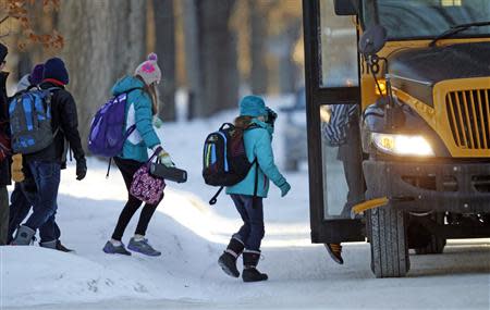 Students board their school bus in a sub-zero temperature in Minneapolis, January 8, 2014. REUTERS/Eric Miller