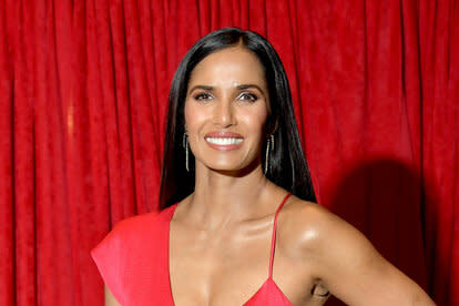 Padma Lakshmi wearing a red dress posing for a photo.