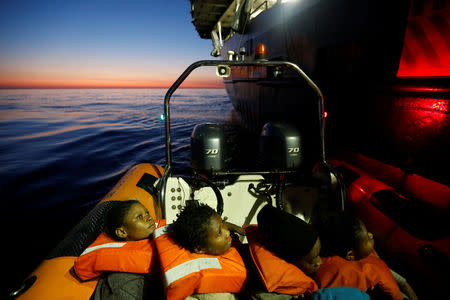 Migrants rescued from a rubber dinghy are brought to the Malta-based NGO Migrant Offshore Aid Station (MOAS) ship Phoenix at dawn in the central Mediterranean in international waters off the coast of Sabratha in Libya, April 15, 2017. REUTERS/Darrin Zammit Lupi