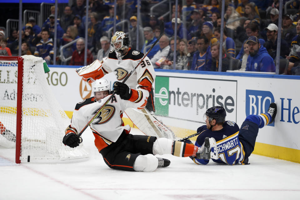 Anaheim Ducks' Cam Fowler (4) falls after colliding with St. Louis Blues' Jaden Schwartz (17) while chasing after a loose puck as Ducks goaltender John Gibson (36) watches during the second period of an NHL hockey game Monday, Jan. 13, 2020, in St. Louis. (AP Photo/Jeff Roberson)