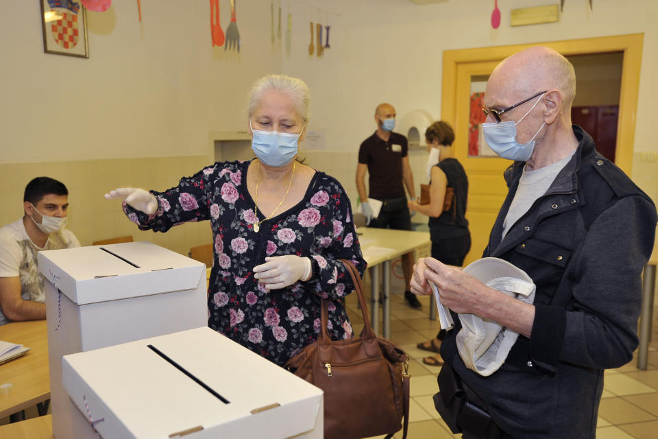 Voters casts ballots at a polling station in Zagreb, Croatia, Sunday, July 5, 2020. Amid a spike of new coronavirus cases, voters in Croatia cast ballots on Sunday in what is expected be a close parliamentary race that could push the latest European Union member state further to the right. (AP Photo)