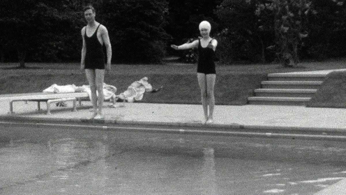 Princess Elizabeth takes a quick dip in the pool with her father King George VI on a bright day in Britain.