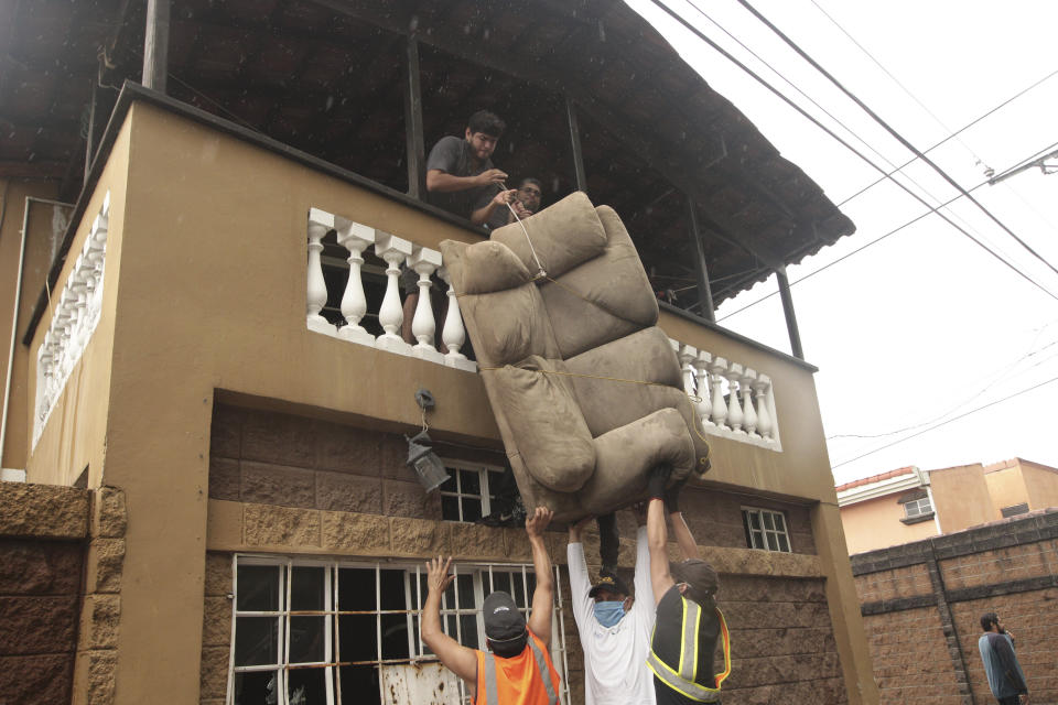 Residents salvage a couch from their home after a flash flood by Acelhuate River, in a neighborhood of San Salvador, El Salvador, Sunday, May 31, 2020. According to the Ministry of the Interior, at least seven people died across the country after two days of heavy rains. (AP Photo/Salvador Melendez)