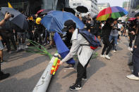 A demonstrator uses a squirt gun to try and write on a fallen smart lamppost during a protest in Hong Kong, Saturday, Aug. 24, 2019. Chinese police said Saturday they released an employee at the British Consulate in Hong Kong as the city's pro-democracy protesters took to the streets again, this time to call for the removal of "smart lampposts" that raised fears of stepped-up surveillance. (AP Photo/Kin Cheung)