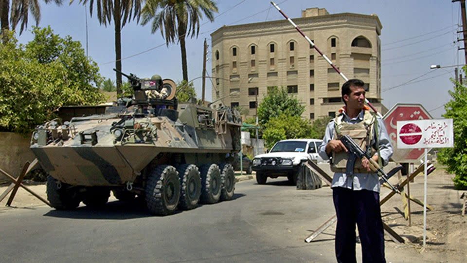 Australian troops aboard an armoured personnel vehicle pass by a checkpoint guarded by an Iraqi policeman at a junction near the Australian embassy in Baghdad, Iraq July 25, 2004. Photo: AP