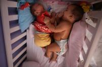 Five-month-old twins, Laura (L) and Lucas lie in their bed at their house in Santos, Sao Paulo state, Brazil April 20, 2016. REUTERS/Nacho Doce