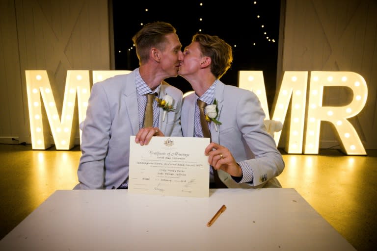 Australian athletes Craig Burns (L) and Luke Sullivan kiss after their marriage ceremony at Summergrove Estate, New South Wales on January 9, 2018