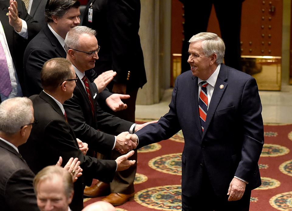 Gov. Mike Parson, right, is greeted by Rep. Doug Richey on Wednesday as Parson enters the Missouri House of Representatives to give the annual State of the State address.