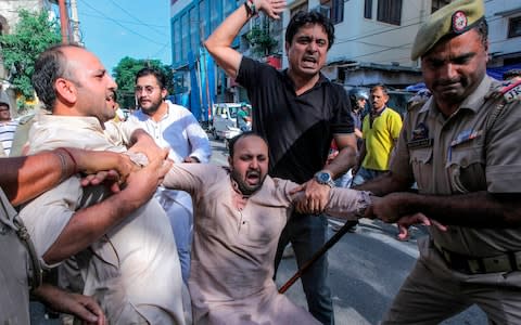 Police personnel struggle to detain an activist of Jammu and Kashmir Youth Congress - Credit: RAKESH BAKSHI/AFP