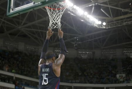 Carmelo Anthony (USA) of the USA hangs from the net near the end of the game. REUTERS/Jim Young