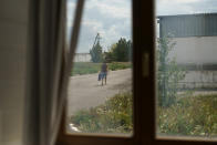 A worker arrives for a shift at the KramAgroSvit dairy farm in Dmytrivka, Donetsk region, eastern Ukraine, Wednesday, Aug. 10, 2022. Only around one-third of the farm's previous staff of 63 employees remains, and revenues have dropped six-fold since Russian forces opened their offensive to seize the Donbas, an industrial region made up of the Donetsk and neighboring Luhansk provinces. (AP Photo/David Goldman)