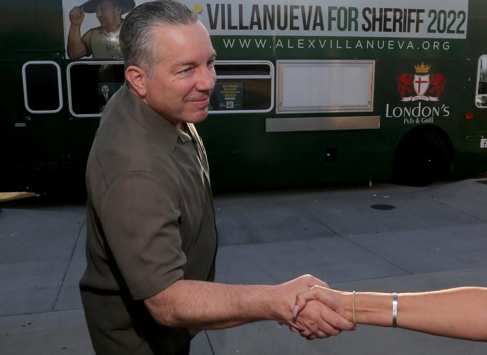 A man shakes the hand of a person who is off-camera