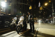 New York City police officers keep watch over a group of protestors demonstrating against Mayor Adams outside Manhattan criminal courts building, Thursday, March 30, 2023, in New York. (AP Photo/Mary Altaffer)