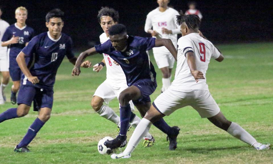 McKeel's Calvin Steele dribbles between two King defenders during overtime on Wednesday night in the Class 4A, Region 3 final.