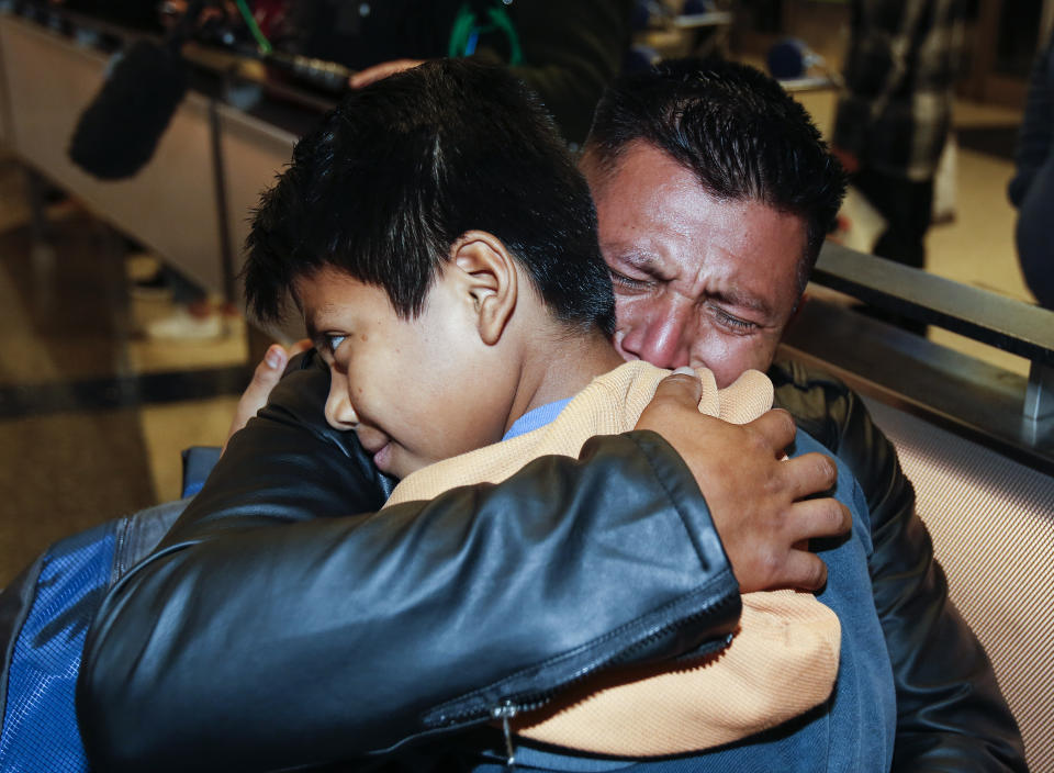 FILE - David Xol-Cholom, of Guatemala, hugs his son Byron Xol-Cholom at Los Angeles International Airport as they reunite after being separated about one and half years earlier during the Trump administration's wide-scale separation of immigrant families in Los Angeles on Jan. 22, 2020. Stalled negotiations for the U.S. government to pay families separated at the border during Trump's presidency have brought new threats of extortion. While specific reports are isolated, widespread extortion in Central America explains why many seek asylum in the United States in the first place and some advocates fear prospects of a large payment will fuel many more threats. (AP Photo/Ringo H.W. Chiu, File)