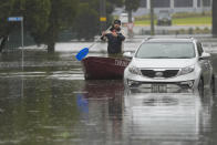 A man paddles his boat down a flooded street at Windsor on the outskirts of Sydney, Australia, Tuesday, July 5, 2022. Hundreds of homes have been inundated in and around Australia's largest city in a flood emergency that was threatening 45,000 people, officials said on Tuesday. (AP Photo/Mark Baker)