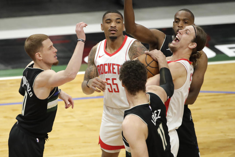 Houston Rockets' Kelly Olynyk, right, gets fouled by Milwaukee Bucks' Brook Lopez (11) during the first half of an NBA basketball game Friday, May 7, 2021, in Milwaukee. (AP Photo/Aaron Gash)