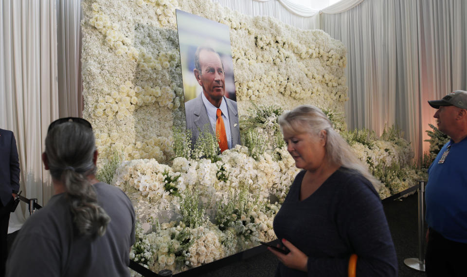 Fans file past a wall of flowers with a portrait of Denver Broncos owner Pat Bowlen placed in the center during a memorial Tuesday, June 18, 2019, at Mile High Stadium, the NFL football team's home in Denver. Bowlen, who has owned the franchise for more than three decades, died last Thursday. (AP Photo/David Zalubowski)