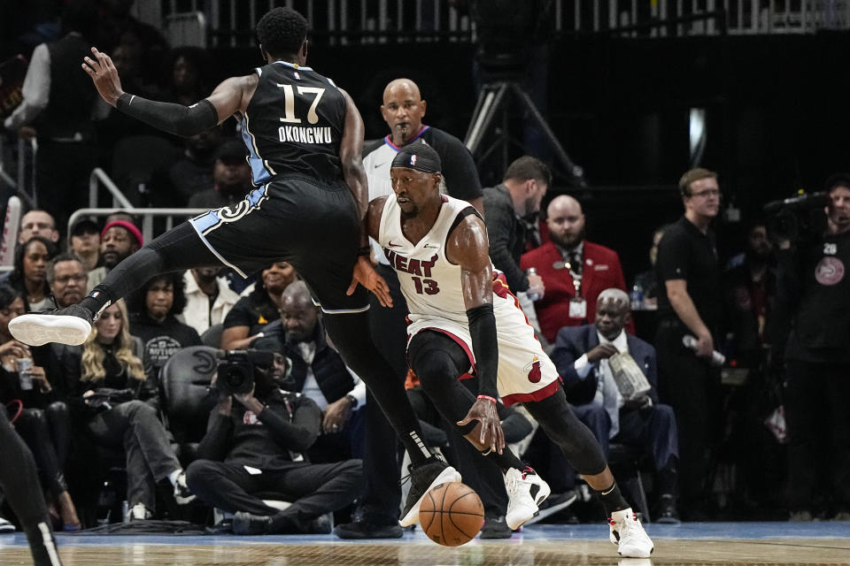 Miami Heat center Bam Adebayo (13) moves the ball against Atlanta Hawks forward Onyeka Okongwu (17) during the first half of an NBA basketball game, Saturday, Nov. 11, 2023, in Atlanta. (AP Photo/Mike Stewart)