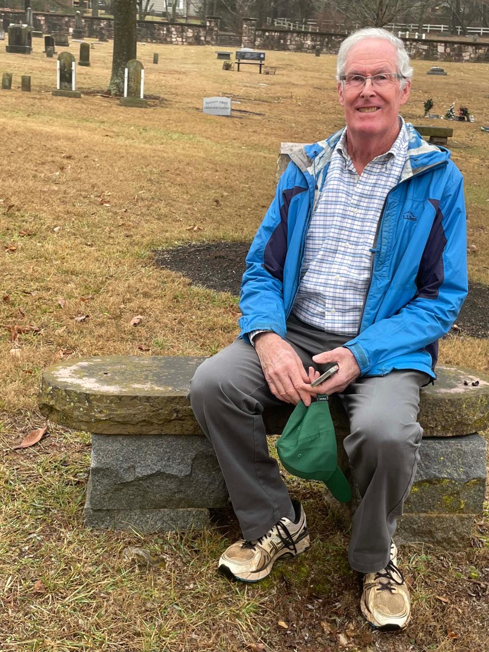 Pleasant Forest Cemetery board member Dave Stinton makes himself comfortable on a bench made from stone rescued from a remodel of the State Capitol nearly 100 years ago. Jan. 18, 2023.