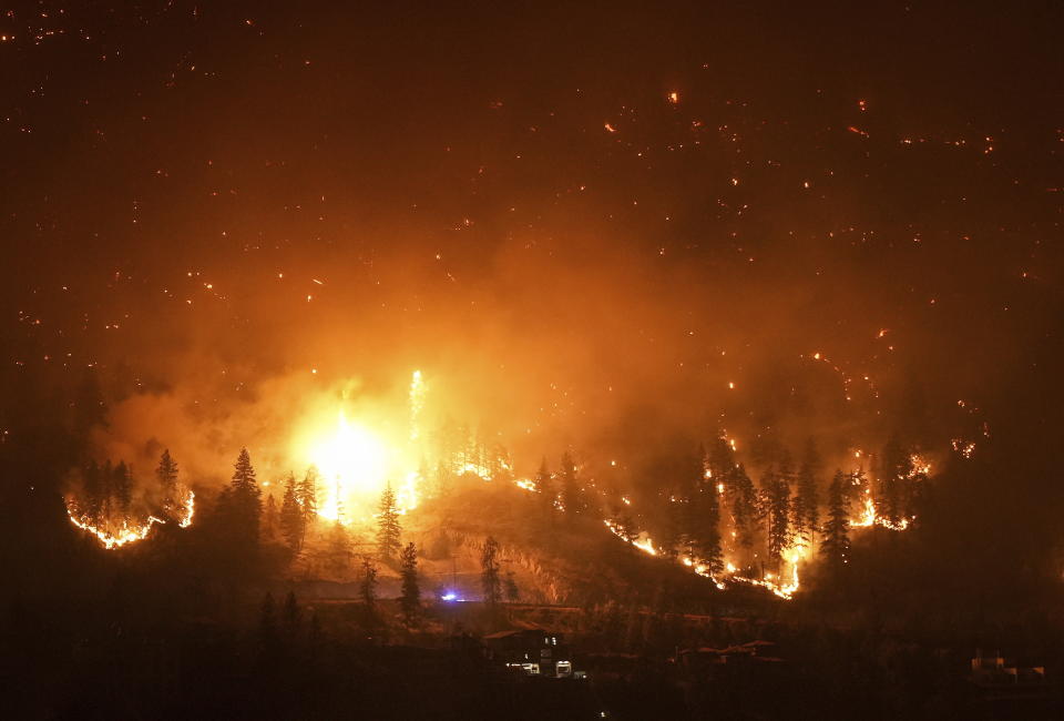 The McDougall Creek wildfire burns on the mountainside above lakefront homes in West Kelowna, Canada on Friday, Aug. 18, 2023. (Darryl Dyck/The Canadian Press via AP)