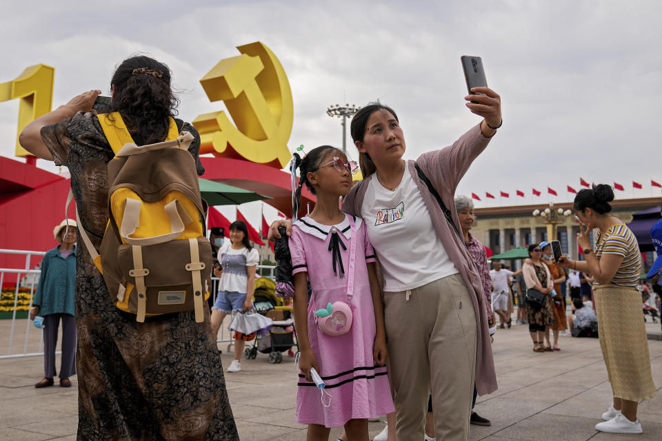 Visitors take souvenir photos with a communist party's logo on display at Tiananmen Square to mark the 100th anniversary of the founding of the ruling Chinese Communist Party in Beijing on Monday, July 5, 2021. Chinese leader Xi Jinping on Tuesday attacked calls from some in the U.S. and its allies to limit their dependency on Chinese suppliers and block the sharing of technologies. (AP Photo/Andy Wong)