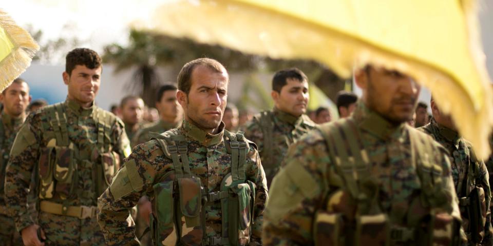 U.S.-backed Syrian Democratic Forces (SDF) stand in formation at a ceremony to mark their defeat of Islamic State militants in Baghouz, at al-Omar Oil Field base, Syria, Saturday, March 23, 2019. (AP Photo/Maya Alleruzzo)