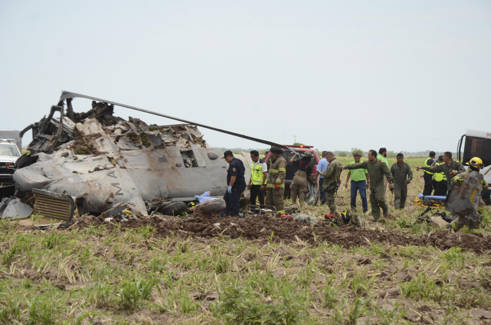 Emergency personnel work next to a navy Blackhawk helicopter crashed after supporting those who conducted the capture of drug lord Rafael Caro Quintero, near Los Mochis, Sinaloa state, Mexico, Friday, July 15, 2022. Mexico's navy said multiple people aboard died. (AP Photo/Guillermo Juarez)