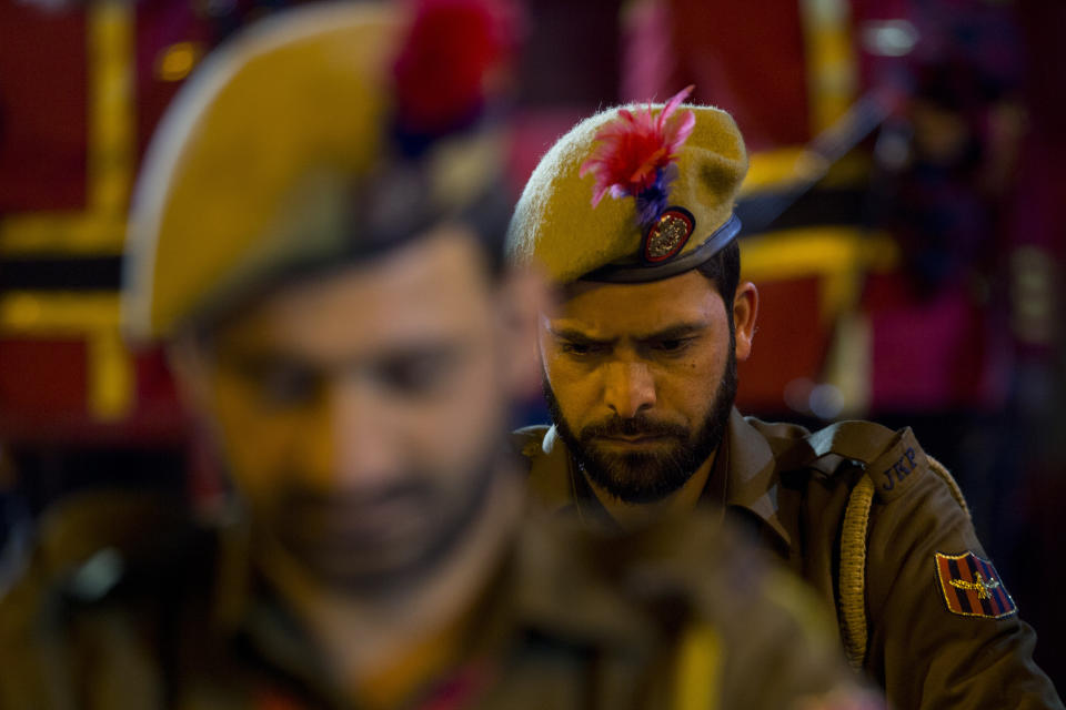 Indian policemen bow their head as they pay homage to their who was killed in a gun battle in Pulwama pray near his coffin during a wreath-laying ceremony in Srinagar, Indian controlled Kashmir, Monday, Feb. 18, 2019. Tensions escalated in the aftermath of a suicide attack in disputed Kashmir, with nine people killed Monday in a gunbattle that broke out as Indian soldiers scoured the area for militants.(AP Photo/ Dar Yasin)