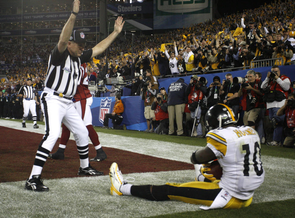 FILE - Field judge Greg Gautreaux raises his arms signaling a touchdown as Pittsburgh Steelers wide receiver Santonio Holmes (10) sits on the ground after scoring during the fourth quarter of the NFL Super Bowl XLIII football game against the Arizona Cardinals, Sunday, Feb. 1, 2009, in Tampa, Fla. The Steelers won 27-23. When it comes to officiating, NFL fans — not to mention players and coaches — tend to remember the misses or mistakes, real or perceived, more than calls that were right, particularly in late-season games. (Brian Cassella/Tampa Bay Times via AP, File)