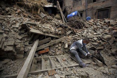 An earthquake victim works near his collapsed house after last week's earthquake in Bhaktapur, Nepal 2 May 2015. REUTERS/Navesh Chitrakar