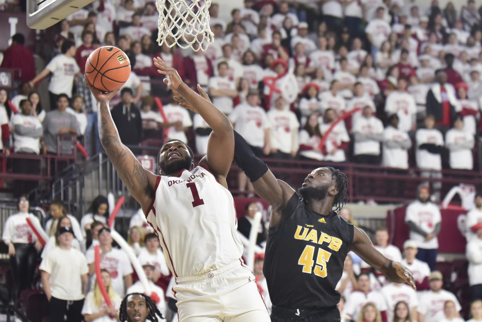 Oklahoma forward John Hugley IV (1) goes up for a shot over Arkansas-Pine Bluff forward Ismael Plet (45) during the first half of an NCAA college basketball game in Norman, Okla., Thursday, Nov. 30, 2023. (AP Photo/Kyle Phillips)