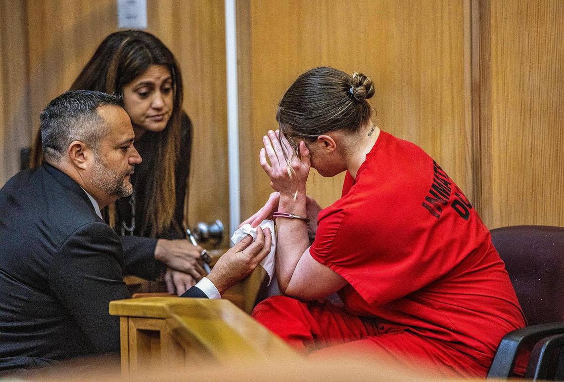 Defense attorneys Sabrina Puglisi and Frank Prieto talk to their client, Courtney Clenney, as she reacts after Judge Laura Shearon Cruz’s decision to keep her in jail to await trial.