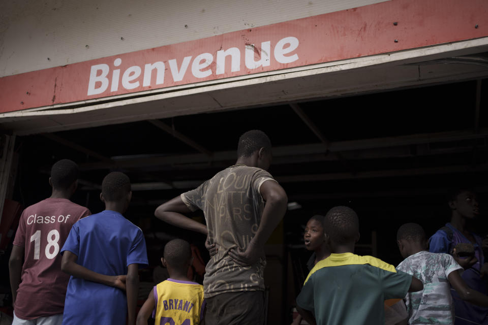 People stand at the entrance of a destroyed supermarket in Dakar, Senegal, Saturday, June 3, 2023. Senegal's government says at least nine people have been killed in violent clashes between police and supporters of opposition leader Ousmane Sonko, with authorities issuing a blanket ban on the use of several social media platforms in the aftermath of the violence. (AP Photo/Leo Correa)