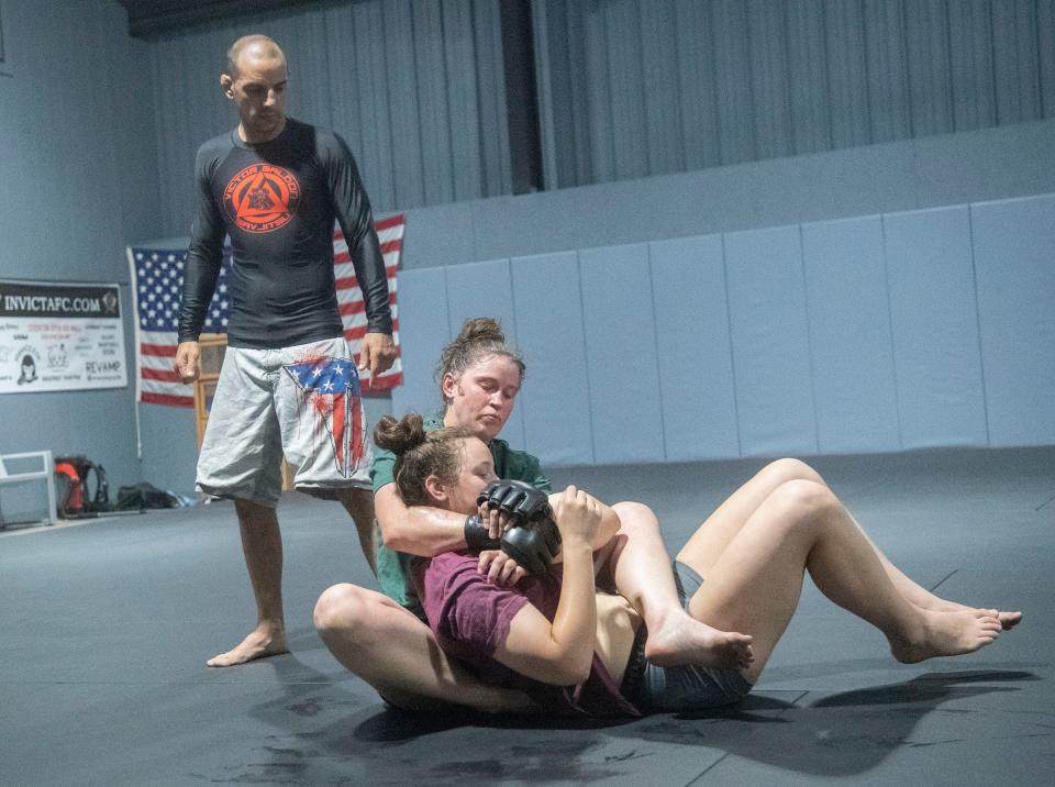 UFC fighter Chelsea Chandler, top, grapples with her sister Carlene Chandler as Jiu Jitsu/Russian Sambo instructor Victor Galdon looks on at the Gracie Fighter Stockton gym in Stockton on Wednesday, June 22, while training for an upcoming October fight in Las Vegas. 