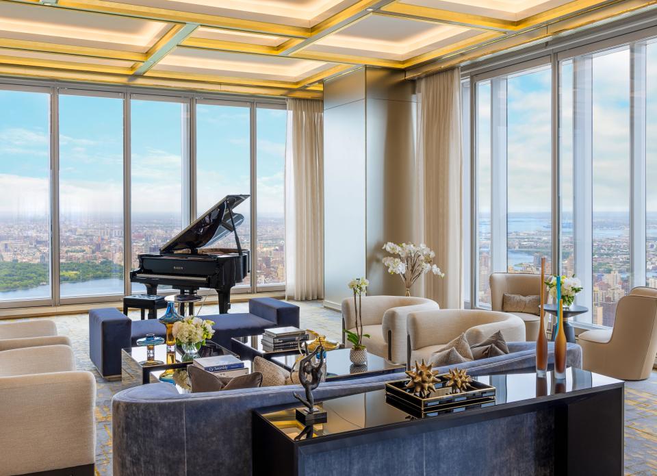 a piano in a spacious white room with floor-to-ceiling windows on the 100th floor of luxury skyscraper Central Park Tower