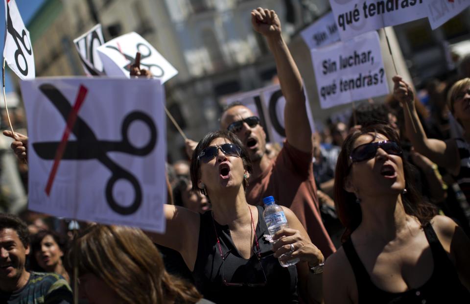 Civil servants shouts slogans condemning the recent austerity measures announced by the Spanish government, during a demonstrations in Madrid, Spain, on Friday July 13, 2012. Spanish civil servants, some dressed in the black of mourning, took to the streets Friday to protest their second wave of wage cuts in as many years as the government prepared to approve austerity measures that include those reductions as part of a deficit-cutting plan to save euro 65 billion through 2015. (AP Photo/Emilio Morenatti)