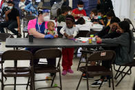 Migrants pass the time at a migrant shelter, Wednesday, May 12, 2021, in McAllen, Texas. The U.S. government continues to report large numbers of migrants crossing the U.S.-Mexico border with an increase in adult crossers. But families and unaccompanied children are still arriving in dramatic numbers despite the weather changing in the Rio Grande Valley registering hotter days and nights. (AP Photo/Gregory Bull)