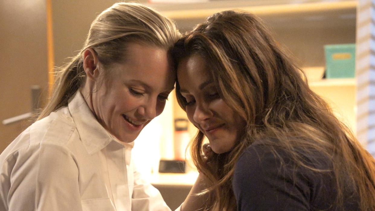  Danielle Savre as Maya Bishop and Stefania Spampinato as Carina DeLuca smile with their foreheads pressed together as they look down during a scene on Station 19. 