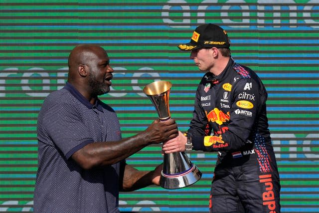 Shaquille O’Neal, left, hands the winner’s trophy to Red Bull driver Max Verstappen