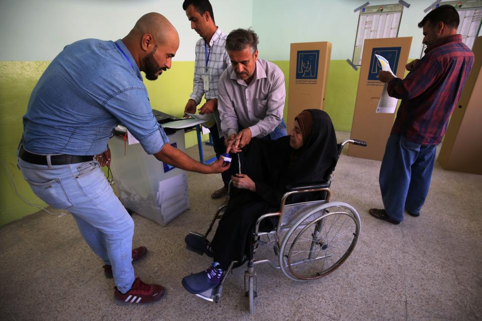 <p>An Iraqi voter casts her vote at a polling station in the city of Mosul on May 12, 2018, still partially in ruins from the devastating months-long fight to oust the Islamic State (IS) group. (Photo: Ahmad Al-Rubaye/AFP/Getty Images) </p>