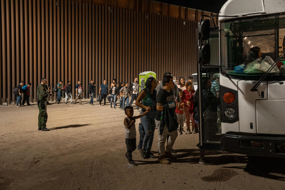 A U.S. Border Patrol agent monitors immigrants as they enter a Border Patrol vehicle to be taken for processing, after crossing the border from Mexico on Aug. 6, 2022, in Yuma, Arizona. / Credit: Qian Weizhong/VCG/Getty Images